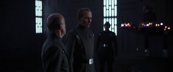 Movie still from “Rogue One: A Star Wars Story” (2016), directed by Gareth Edwards – A group of men standing next to each other in a room; Medium shot, Over the shoulder angle