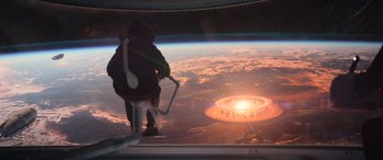 Movie still from “Rogue One: A Star Wars Story” (2016), directed by Gareth Edwards – A person standing in front of an earth with an explosion in the background; Extreme Wide shot, Overhead angle