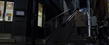 Movie still from “Ronin” (1998), directed by John Frankenheimer – A man walking down a set of stairs; Wide shot, Low angle