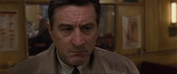 Movie still from “Ronin” (1998), directed by John Frankenheimer – A person wearing a suit and tie; Close Up shot, Low angle