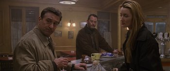 Movie still from “Ronin” (1998), directed by John Frankenheimer – A couple of men sitting at a table in a room; Medium shot, Low angle