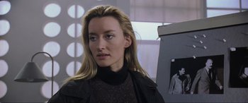 Movie still from “Ronin” (1998), directed by John Frankenheimer – A person with long blonde hair; Close Up shot, Over the shoulder angle