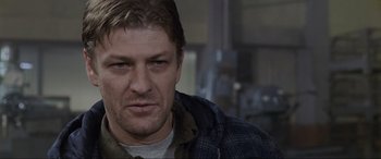 Movie still from “Ronin” (1998), directed by John Frankenheimer – A person wearing a jacket; Close Up shot, Over the shoulder angle