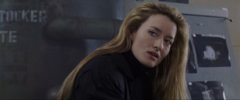 Movie still from “Ronin” (1998), directed by John Frankenheimer – A person with long blonde hair; Close Up shot, Over the shoulder angle