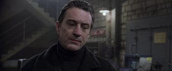 Movie still from “Ronin” (1998), directed by John Frankenheimer – A person wearing a black jacket; Close Up shot, Low angle