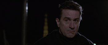 Movie still from “Ronin” (1998), directed by John Frankenheimer – A person wearing a black shirt; Close Up shot, Low angle