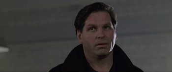 Movie still from “Ronin” (1998), directed by John Frankenheimer – A person wearing a black shirt; Close Up shot, Low angle