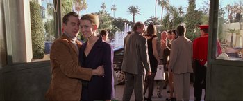 Movie still from “Ronin” (1998), directed by John Frankenheimer – A man and a woman standing next to each other in front of a crowd; Medium shot, Low angle