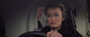 Movie still from “Ronin” (1998), directed by John Frankenheimer – A woman sitting in the drivers seat of a car; Close Up shot, Over the shoulder angle