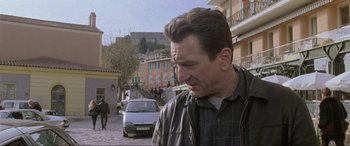 Movie still from “Ronin” (1998), directed by John Frankenheimer – A person standing on a street near a car; Close Up shot, Low angle