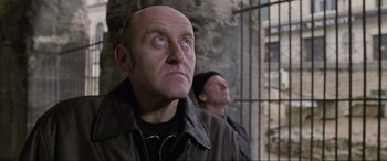 Movie still from “Ronin” (1998), directed by John Frankenheimer – A man with a bald head looking up; Close Up shot, Low angle