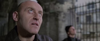 Movie still from “Ronin” (1998), directed by John Frankenheimer – A man with a bald head looking into the distance; Close Up shot, Low angle