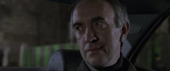 Movie still from “Ronin” (1998), directed by John Frankenheimer – A person wearing a suit and tie; Close Up shot, Low angle