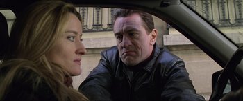 Movie still from “Ronin” (1998), directed by John Frankenheimer – A man and a woman sitting in the back of a car; Close Up shot, Over the shoulder angle