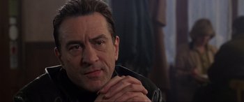 Movie still from “Ronin” (1998), directed by John Frankenheimer – A person wearing a leather jacket; Close Up shot, Over the shoulder angle