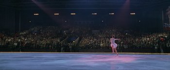 Movie still from “Ronin” (1998), directed by John Frankenheimer – A man in white shirt and shorts performing on a stage; Extreme Wide shot, High angle