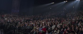 Movie still from “Ronin” (1998), directed by John Frankenheimer – A crowd of people sitting in a dark room; Extreme Wide shot, High angle