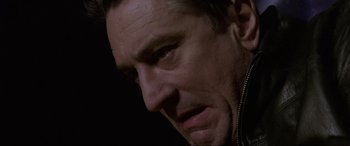 Movie still from “Ronin” (1998), directed by John Frankenheimer – A man's face in a dark room; Close Up shot, Low angle