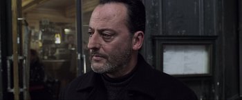 Movie still from “Ronin” (1998), directed by John Frankenheimer – A person wearing a black jacket; Close Up shot, Over the shoulder angle