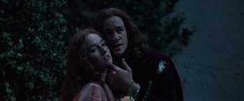 Movie still from “Rosaline” (2022), directed by Karen Maine – A man and a woman standing next to each other in the dark; Close Up shot, High angle