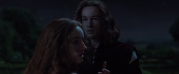 Movie still from “Rosaline” (2022), directed by Karen Maine – A man and a woman standing next to each other in the dark; Close Up shot, Over the shoulder angle