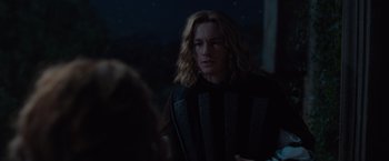 Movie still from “Rosaline” (2022), directed by Karen Maine – A man with blonde hair and a black and white striped shirt; Medium shot, Over the shoulder angle