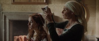 Movie still from “Rosaline” (2022), directed by Karen Maine – An older woman dries the hair of a young girl; Close Up shot, Over the shoulder angle