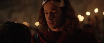 Movie still from “Rosaline” (2022), directed by Karen Maine – A man with long brown hair wearing sunglasses; Close Up shot, Over the shoulder angle