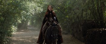 Movie still from “Rosaline” (2022), directed by Karen Maine – A woman riding on the back of a brown horse; Wide shot, Low angle