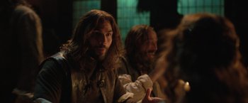 Movie still from “Rosaline” (2022), directed by Karen Maine – A man with long hair and a long beard; Close Up shot, Over the shoulder angle