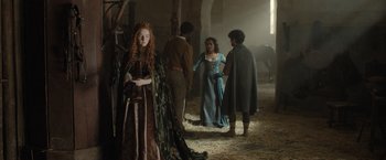 Movie still from “Rosaline” (2022), directed by Karen Maine – A group of people standing around in a barn; Wide shot, Over the shoulder angle