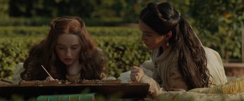 Movie still from “Rosaline” (2022), directed by Karen Maine – Two women sitting at a table looking at a piece of paper; Close Up shot, Over the shoulder angle