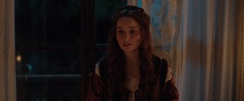 Movie still from “Rosaline” (2022), directed by Karen Maine – A woman with long brown hair wearing a dress; Close Up shot, Over the shoulder angle