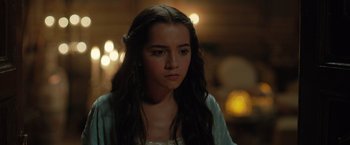 Movie still from “Rosaline” (2022), directed by Karen Maine – A young woman with long dark hair wearing a white dress; Close Up shot, Over the shoulder angle