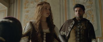 Movie still from “Rosaline” (2022), directed by Karen Maine – A woman with long brown hair wearing a dress; Close Up shot, Over the shoulder angle