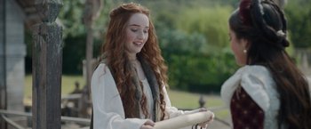 Movie still from “Rosaline” (2022), directed by Karen Maine – A woman with long red curly hair holding something; Close Up shot, Over the shoulder angle