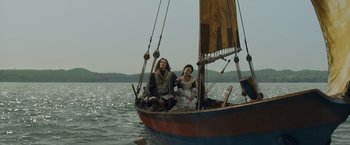 Movie still from “Rosaline” (2022), directed by Karen Maine – Two people sitting on a boat in the water; Wide shot, Low angle