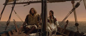 Movie still from “Rosaline” (2022), directed by Karen Maine – A man and a woman sitting on a boat in the water; Medium shot, Low angle