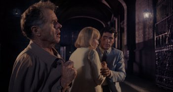 Movie still from “Rosemary's Baby” (1968), directed by Roman Polanski – A group of people standing next to each other on a street; Medium shot, Over the shoulder angle