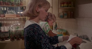 Movie still from “Rosemary's Baby” (1968), directed by Roman Polanski – Two young girls sitting at a sink in a kitchen; Medium shot, Over the shoulder angle