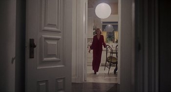 Movie still from “Rosemary's Baby” (1968), directed by Roman Polanski – A woman in a red suit walking through a room; Wide shot, High angle
