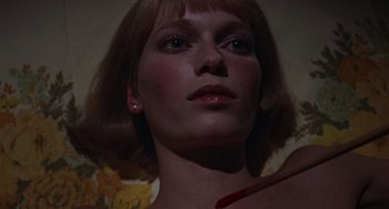 Movie still from “Rosemary's Baby” (1968), directed by Roman Polanski – A woman's face with a knife in it's mouth; Close Up shot, Overhead angle
