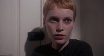 Movie still from “Rosemary's Baby” (1968), directed by Roman Polanski – A woman with red hair is looking into the camera; Close Up shot, Low angle