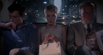 Movie still from “Rosemary's Baby” (1968), directed by Roman Polanski – A woman sitting in a car holding a white purse; Medium shot, High angle