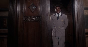 Movie still from “Rosemary's Baby” (1968), directed by Roman Polanski – A man standing in front of a wooden door; Medium shot, Low angle