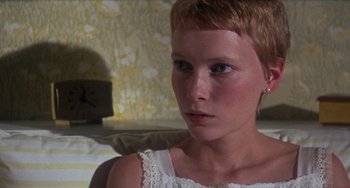 Movie still from “Rosemary's Baby” (1968), directed by Roman Polanski – A woman with short red hair sitting on top of a bed; Close Up shot, Low angle