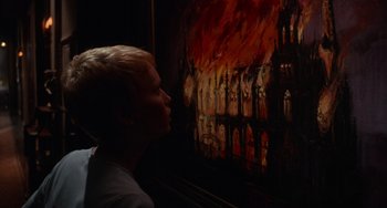Movie still from “Rosemary's Baby” (1968), directed by Roman Polanski – A woman looking at a painting of a church on fire; Close Up shot, Over the shoulder angle