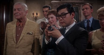 Movie still from “Rosemary's Baby” (1968), directed by Roman Polanski – A group of people standing in a room; Medium shot, Over the shoulder angle