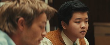 Movie still from “Run & Gun” (2022), directed by Christopher Borrelli – Two young men sitting next to each other in a room; Close Up shot, Over the shoulder angle