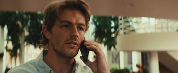 Movie still from “Run & Gun” (2022), directed by Christopher Borrelli – A person talking on a cell phone; Close Up shot, Over the shoulder angle